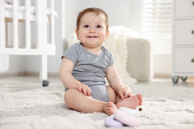 Photo of Cute little baby playing with toys in room
