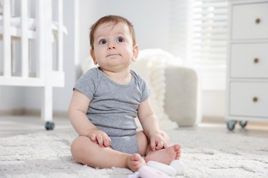 Photo of Cute little baby on floor in room. Space for text