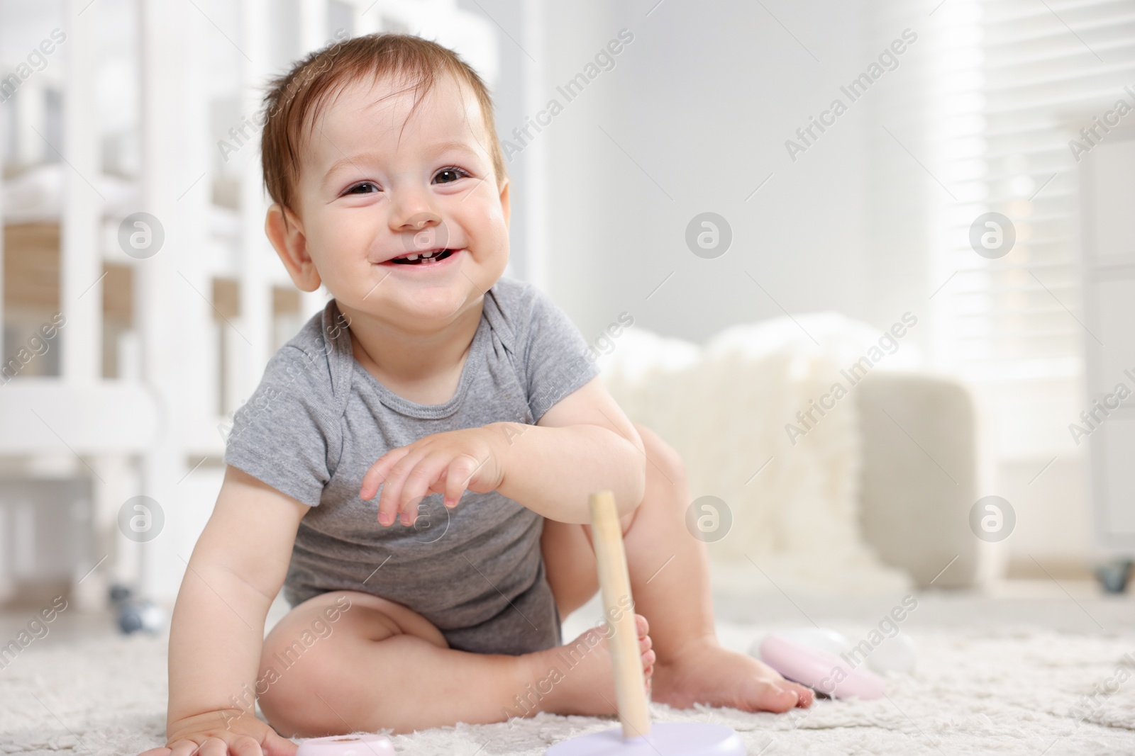 Happy little baby on floor in room. Space for text Photo of Happy little baby on floor in room. Space for text