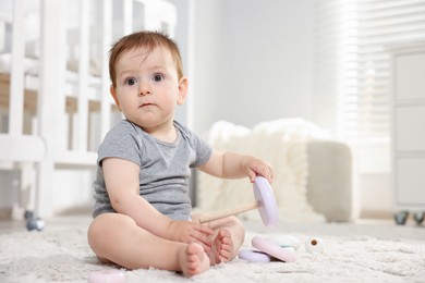 Photo of Cute little baby playing with toy pyramid in room. Space for text