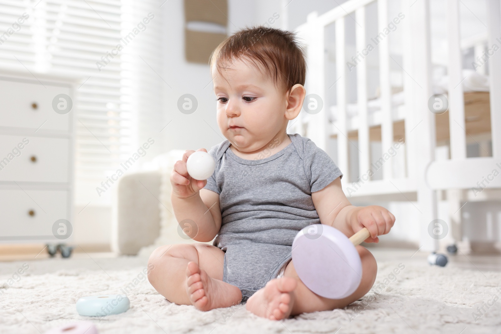 Cute little baby playing with toy pyramid in room Photo of Cute little baby playing with toy pyramid in room