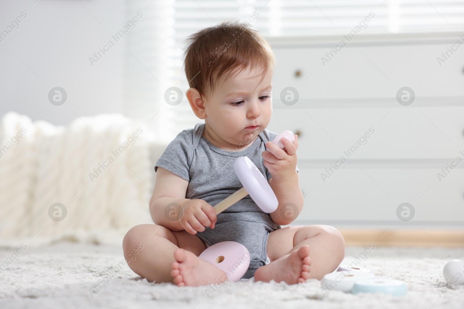 Cute little baby playing with toy pyramid in room Photo of Cute little baby playing with toy pyramid in room