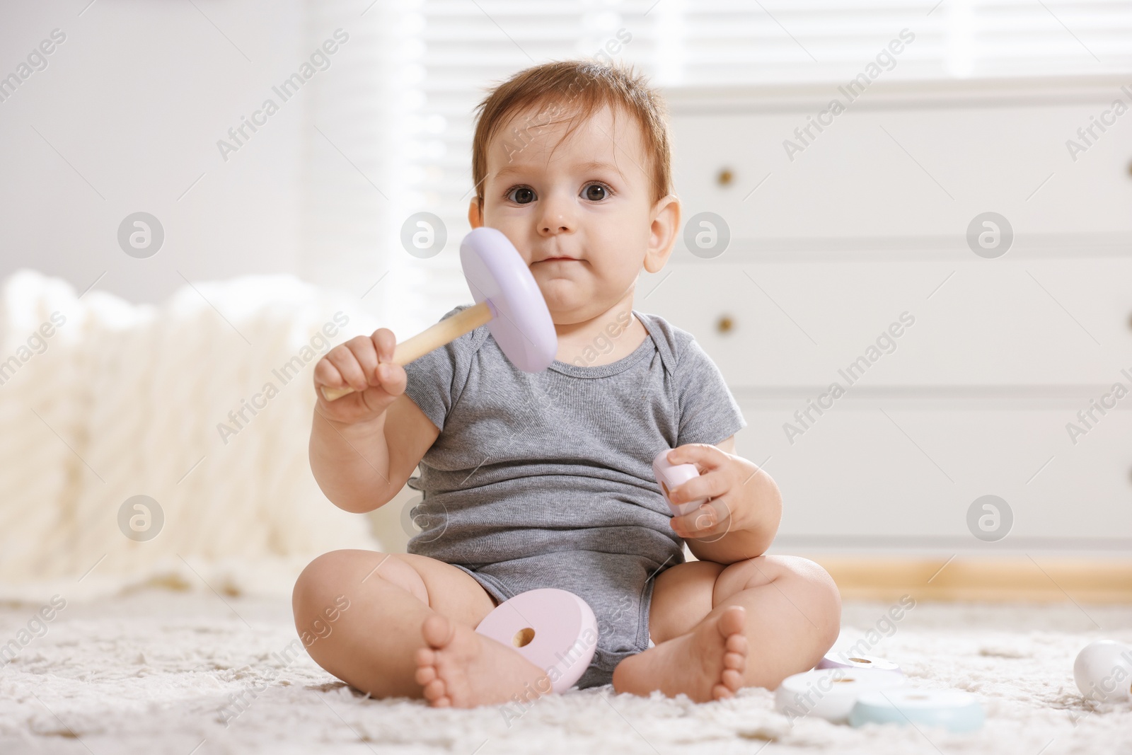 Cute little baby playing with toy pyramid in room Photo of Cute little baby playing with toy pyramid in room