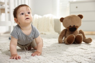 Photo of Cute little baby crawling on floor in room