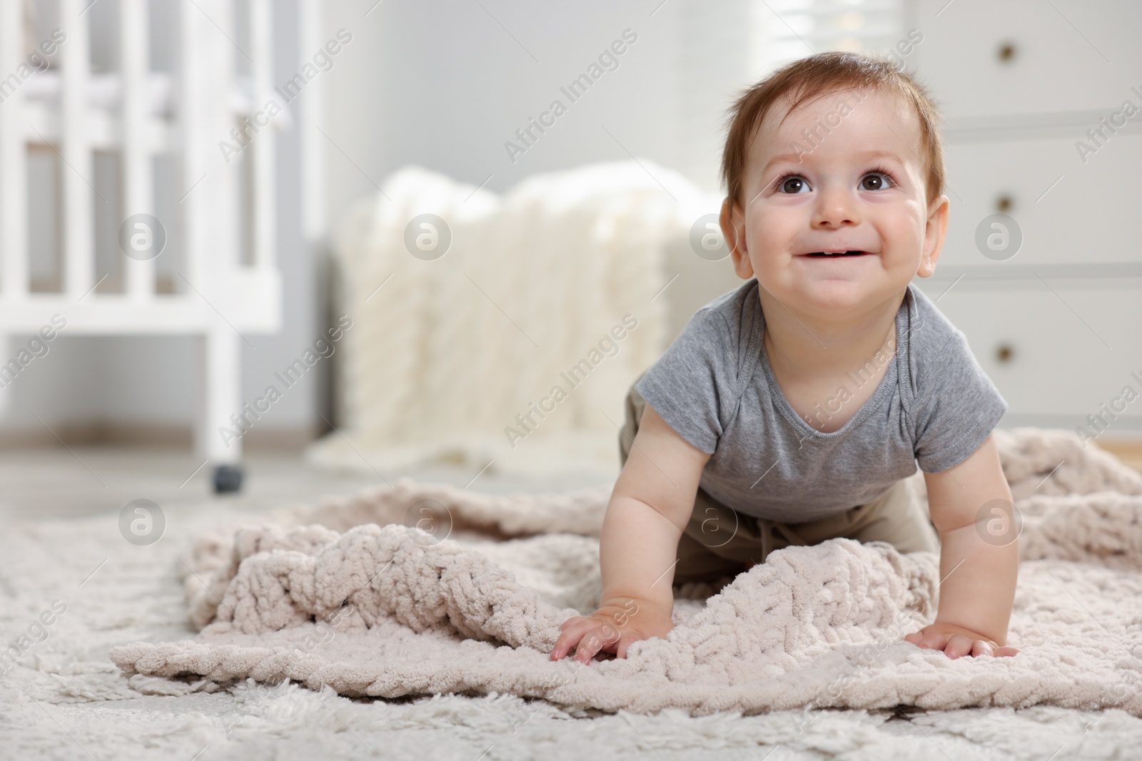 Cute little baby crawling on floor in room. Space for text Photo of Cute little baby crawling on floor in room. Space for text