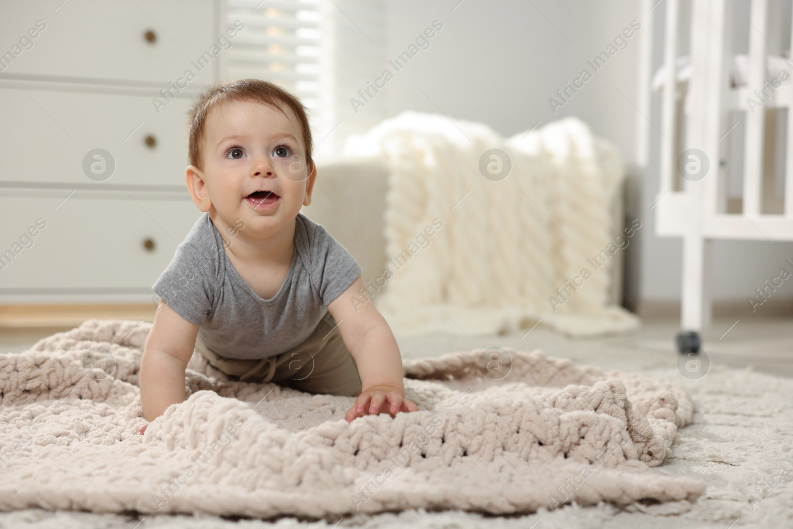 Cute little baby crawling on floor in room. Space for text Photo of Cute little baby crawling on floor in room. Space for text