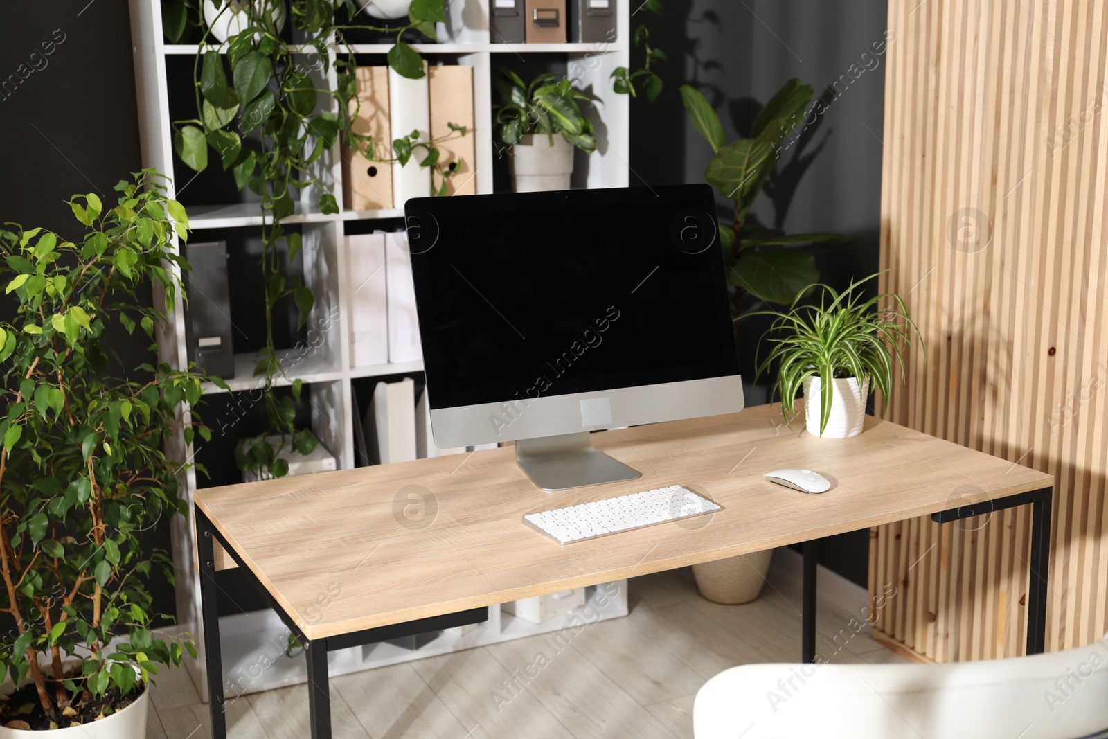 Stylish workplace with modern computer and floral decor in office. Biophilic interior design Photo of Stylish workplace with modern computer and floral decor in office. Biophilic interior design