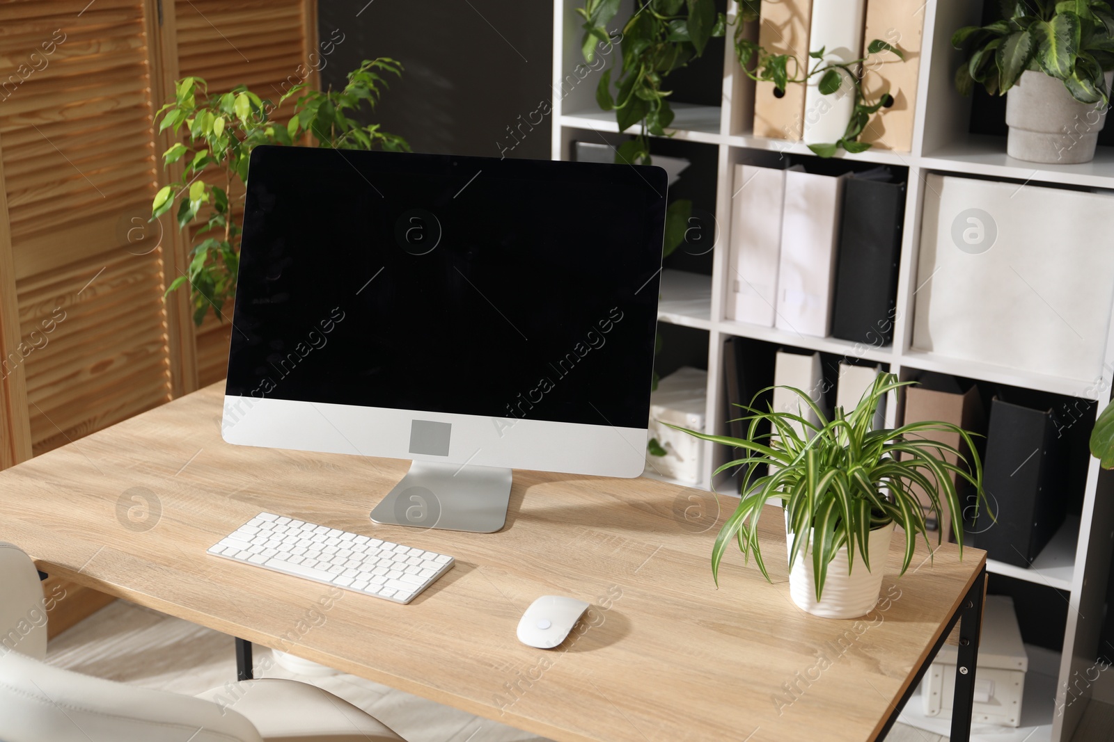 Stylish workplace with modern computer and floral decor in office. Biophilic interior design Photo of Stylish workplace with modern computer and floral decor in office. Biophilic interior design