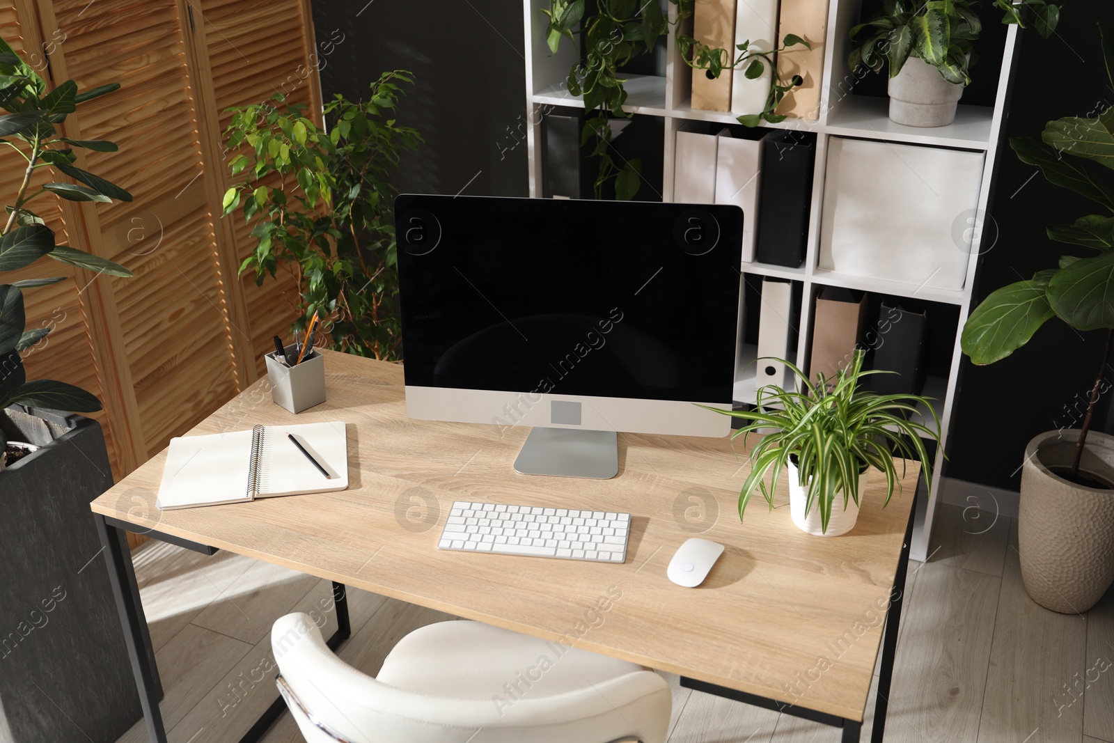 Stylish workplace with modern computer, stationery and floral decor in office, above view. Biophilic interior design Photo of Stylish workplace with modern computer, stationery and floral decor in office, above view. Biophilic interior design