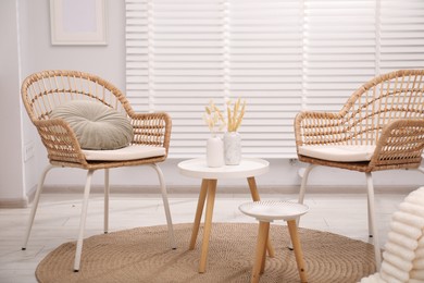 Photo of Comfortable armchairs and tables in living room. Interior design