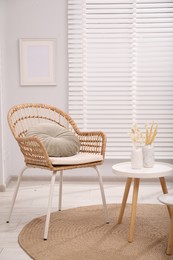 Photo of Comfortable armchair and side table in living room. Interior design