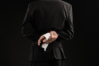 Photo of Young man wearing stylish suit and ring on black background, closeup