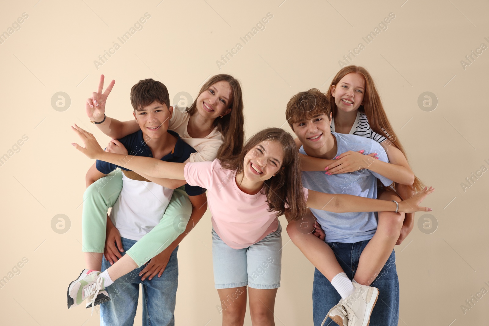 Photo of Portrait of happy teenage friends on beige background