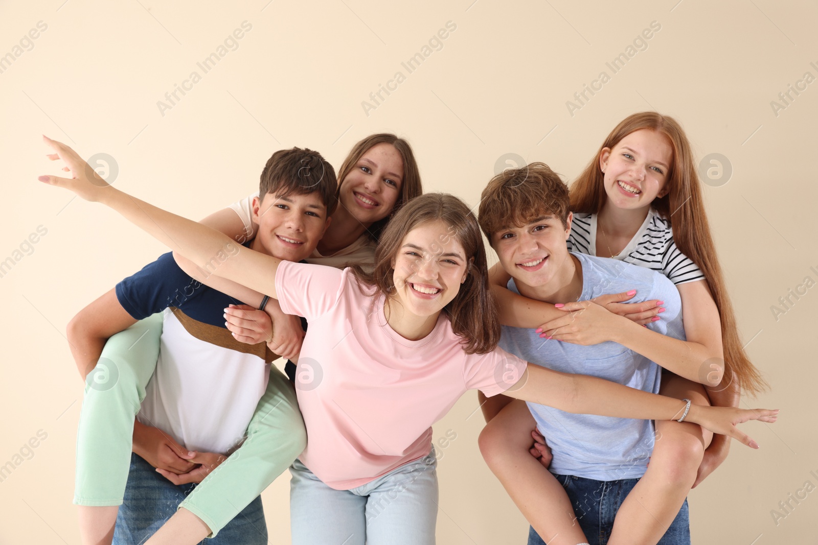 Photo of Portrait of happy teenage friends on beige background