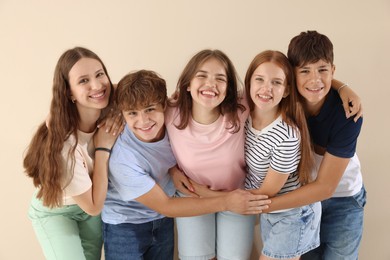 Photo of Portrait of happy teenage friends on beige background