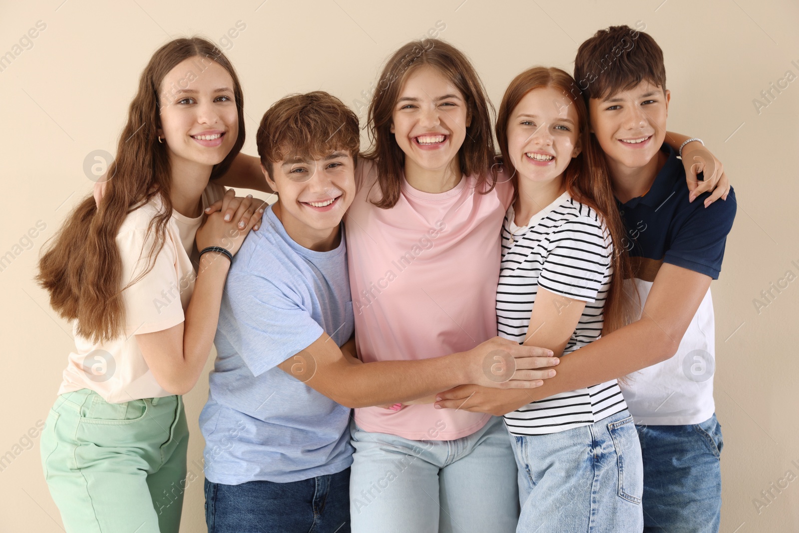 Photo of Portrait of happy teenage friends on beige background