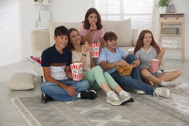 Photo of Happy teenage friends with snacks watching movie indoors