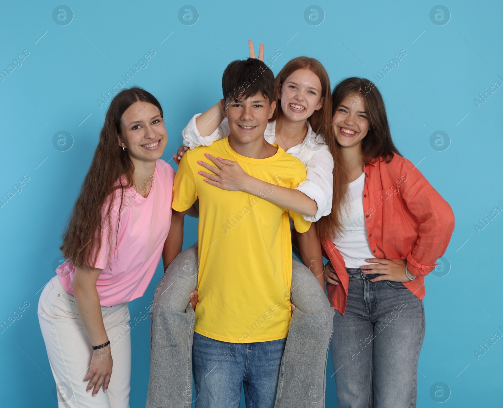 Photo of Portrait of happy teenage friends on light blue background