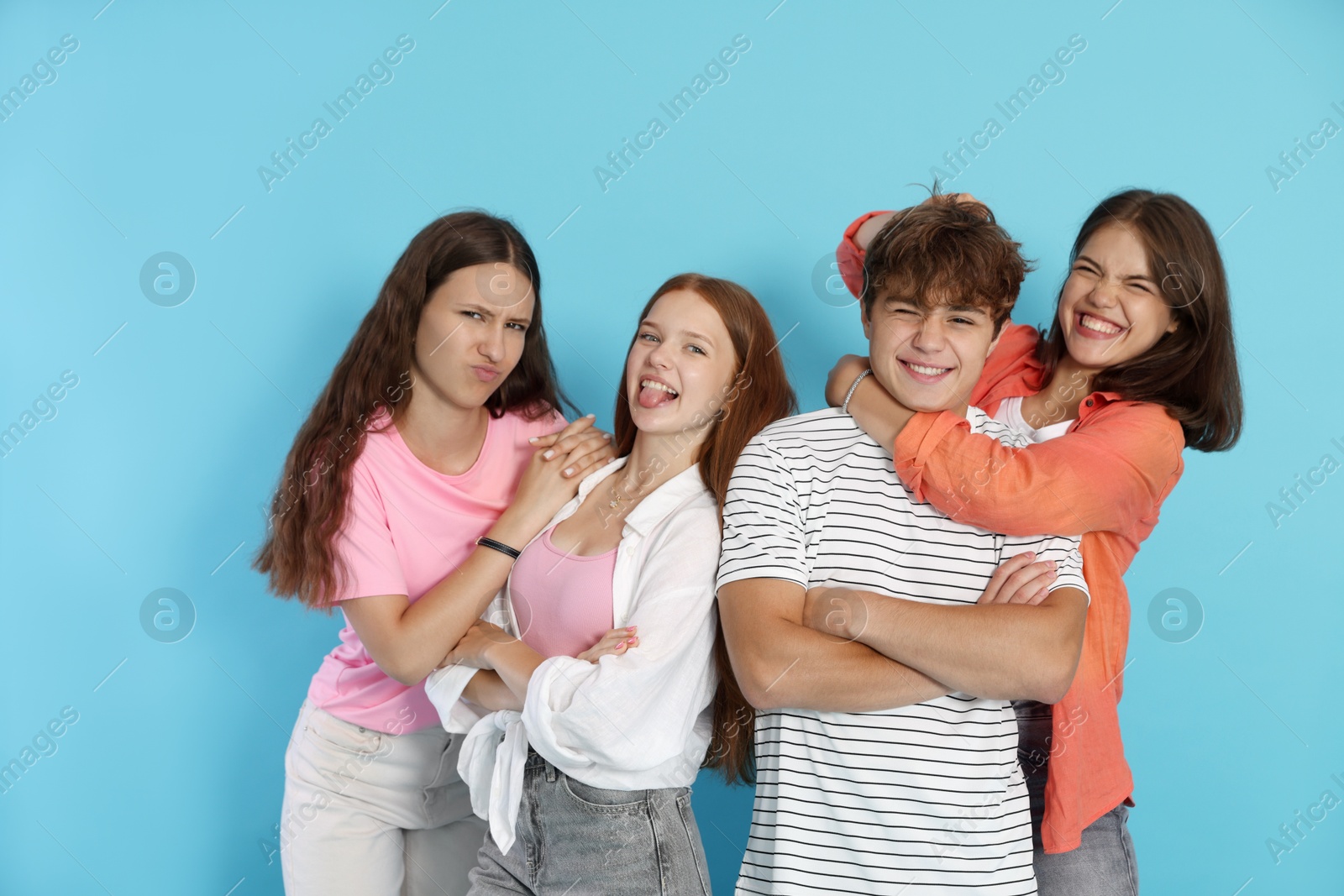 Photo of Portrait of happy teenage friends on light blue background