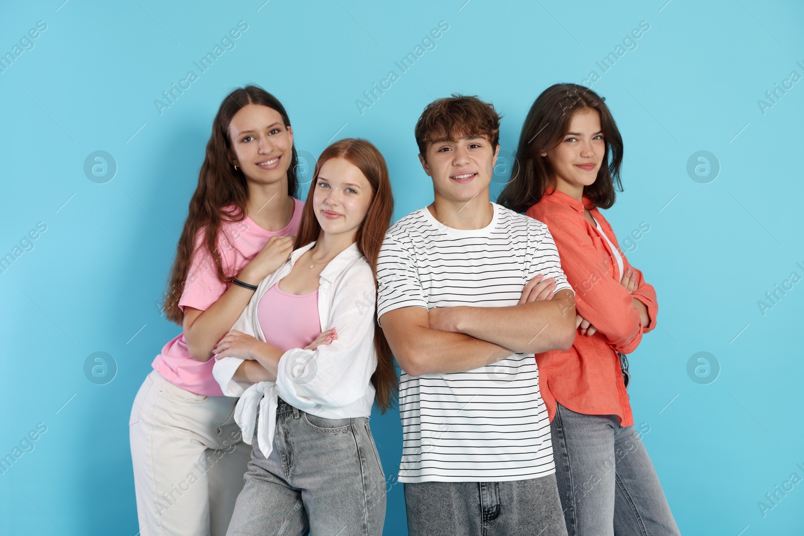 Photo of Portrait of happy teenage friends on light blue background