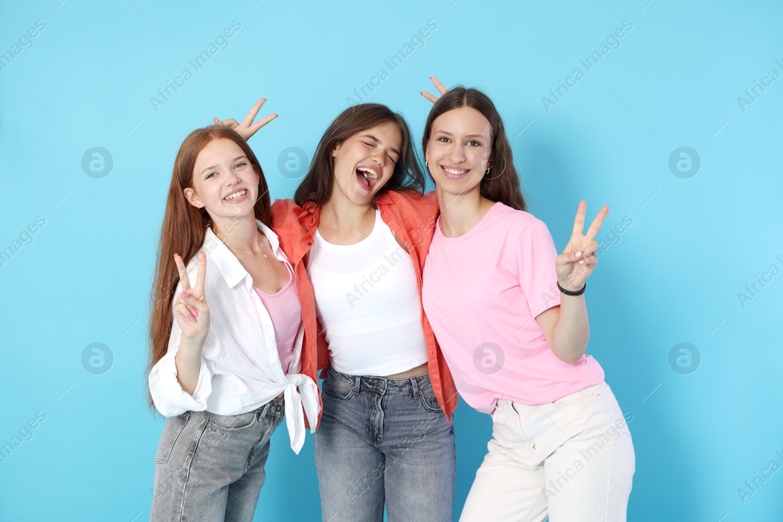 Photo of Portrait of happy teenage friends on light blue background