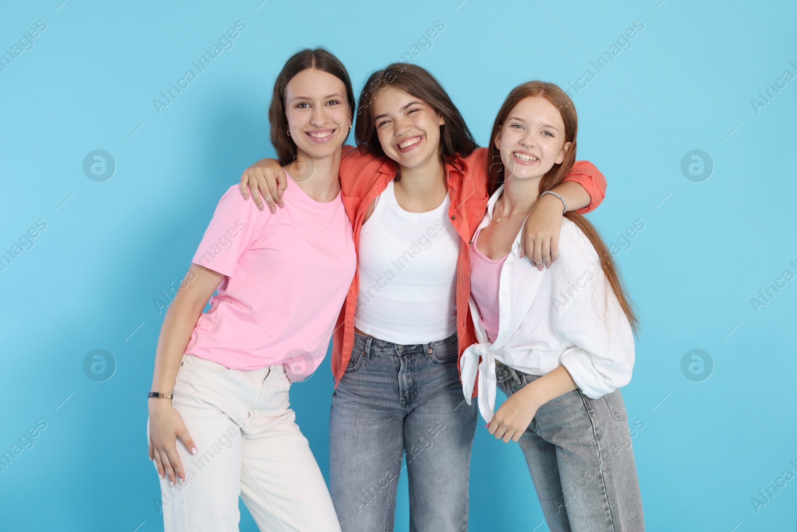 Photo of Portrait of happy teenage friends on light blue background