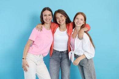 Photo of Portrait of happy teenage friends on light blue background