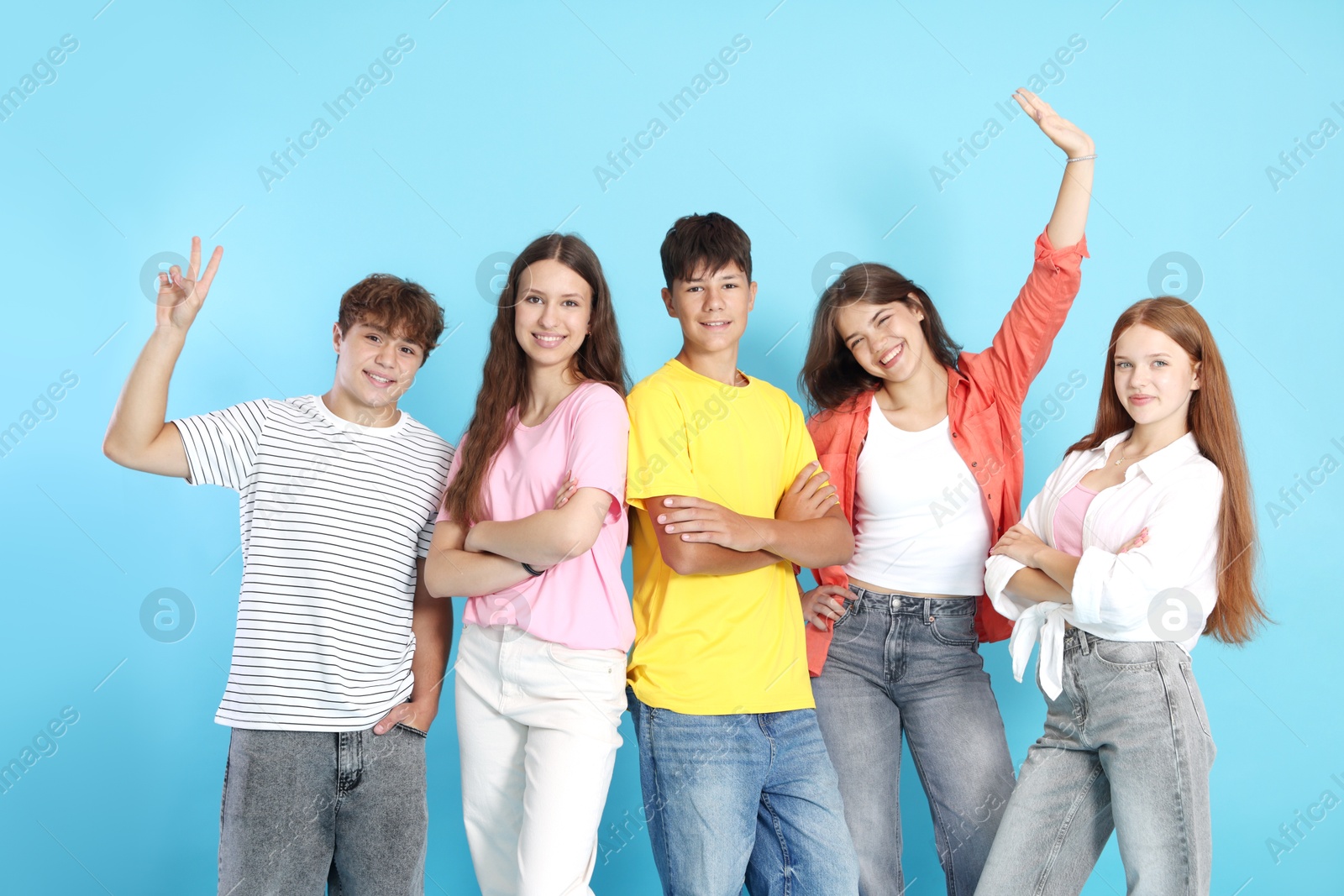 Photo of Portrait of happy teenage friends on light blue background