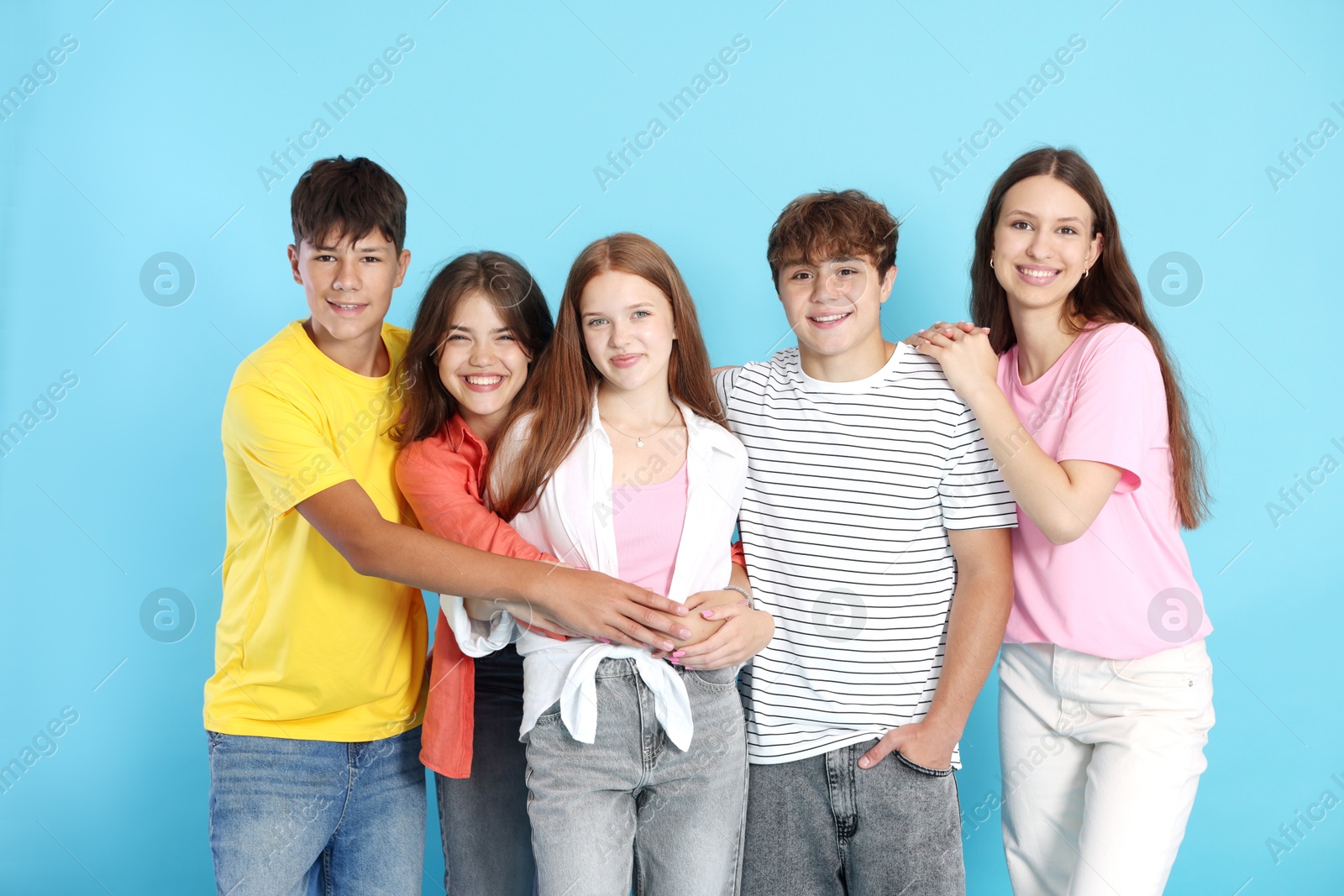 Photo of Portrait of happy teenage friends on light blue background