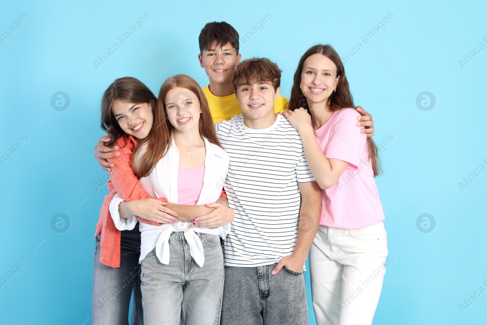 Photo of Portrait of happy teenage friends on light blue background