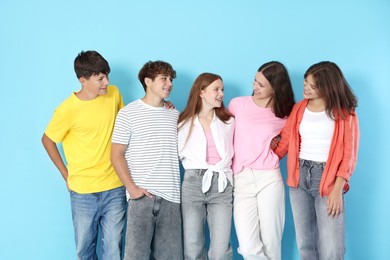 Photo of Portrait of happy teenage friends on light blue background