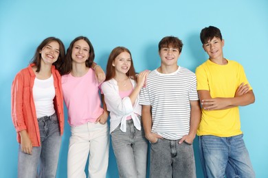 Photo of Portrait of happy teenage friends on light blue background
