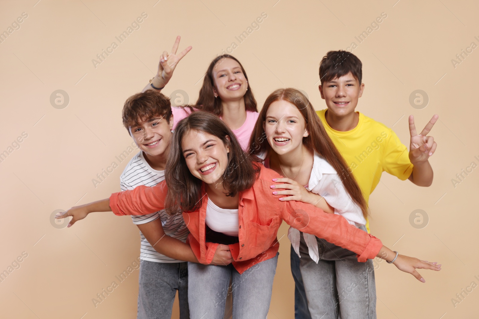 Photo of Portrait of happy teenage friends on beige background