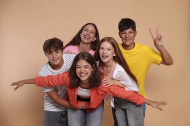 Photo of Portrait of happy teenage friends on beige background