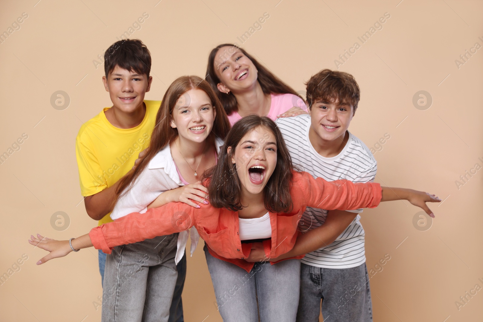 Photo of Portrait of happy teenage friends on beige background