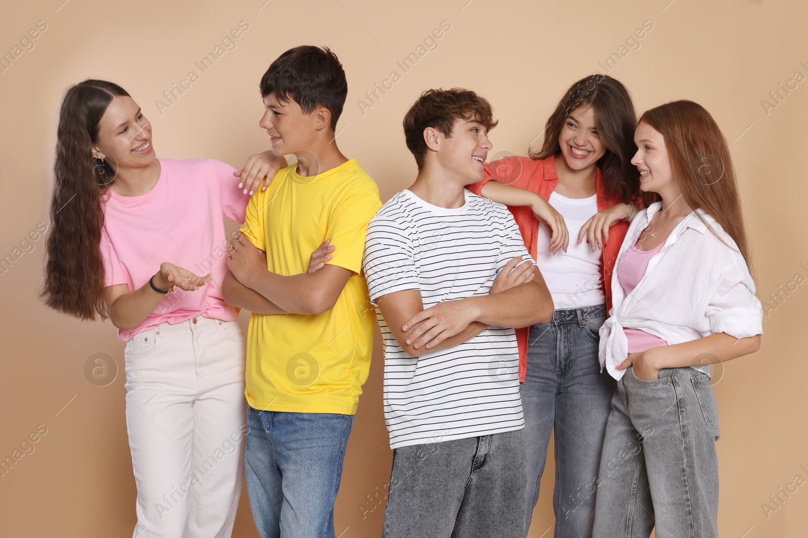 Photo of Portrait of happy teenage friends on beige background