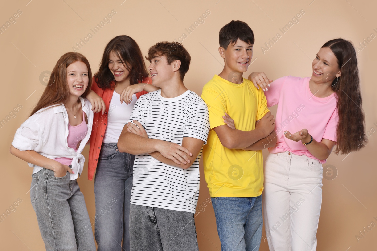 Photo of Portrait of happy teenage friends on beige background