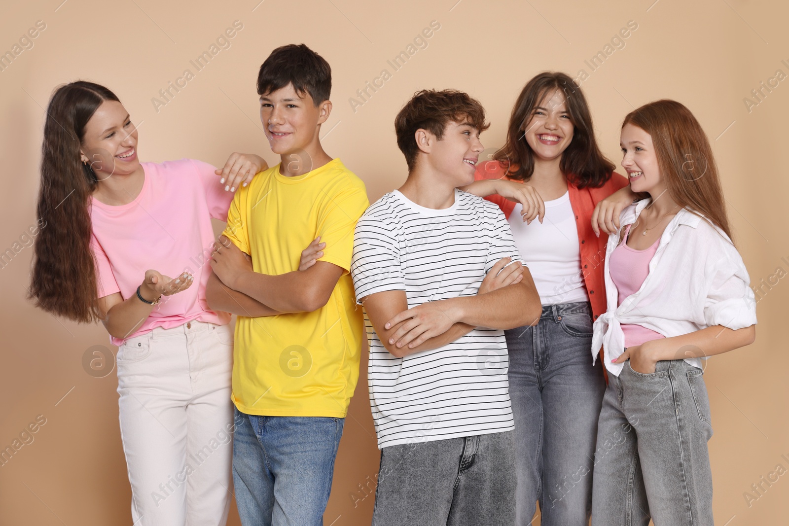Photo of Portrait of happy teenage friends on beige background