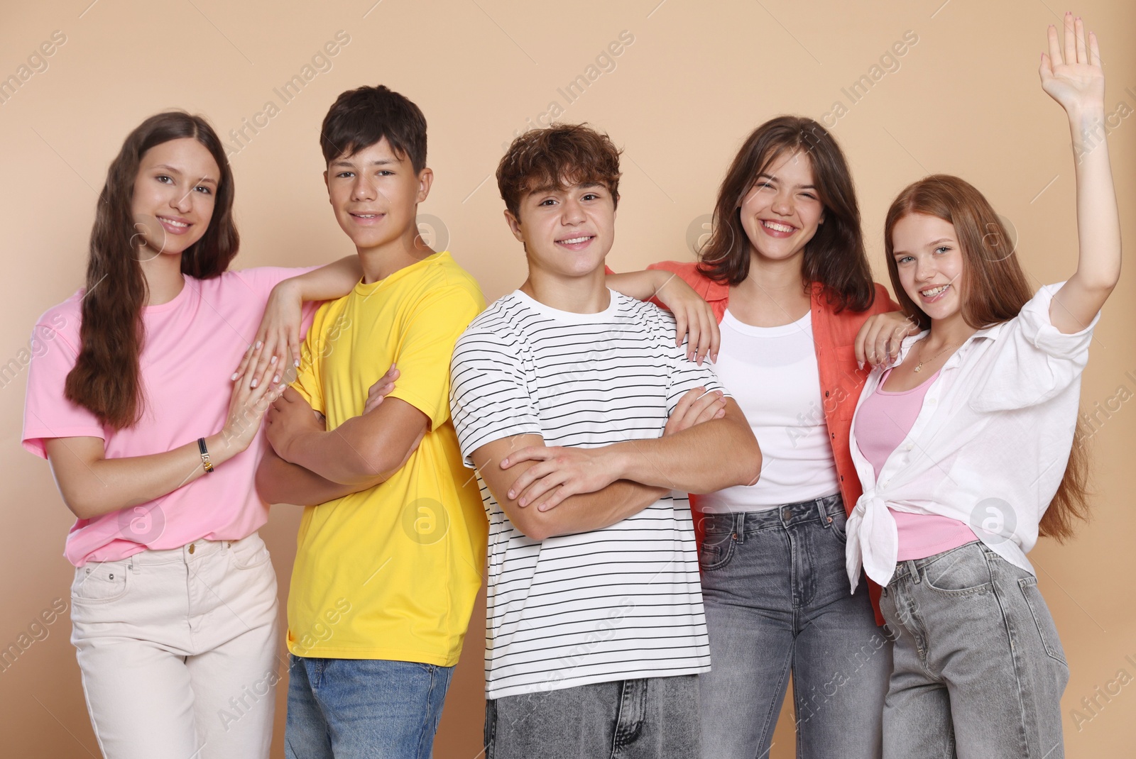 Photo of Portrait of happy teenage friends on beige background