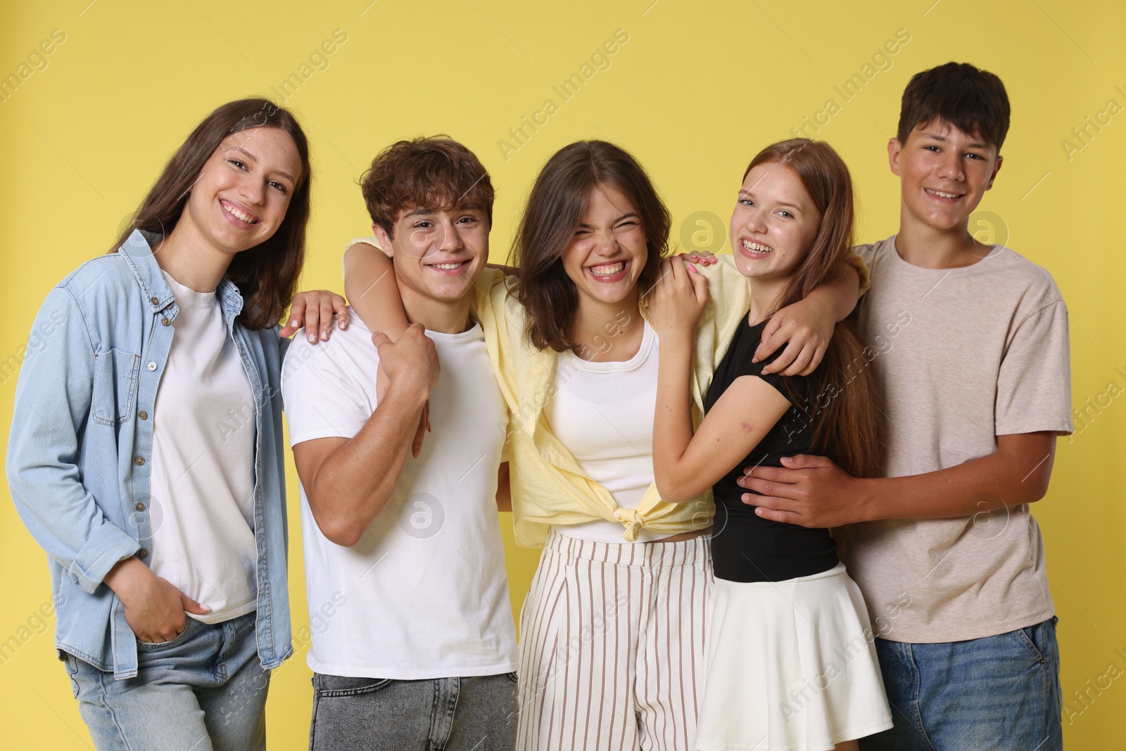 Photo of Portrait of happy teenage friends on yellow background