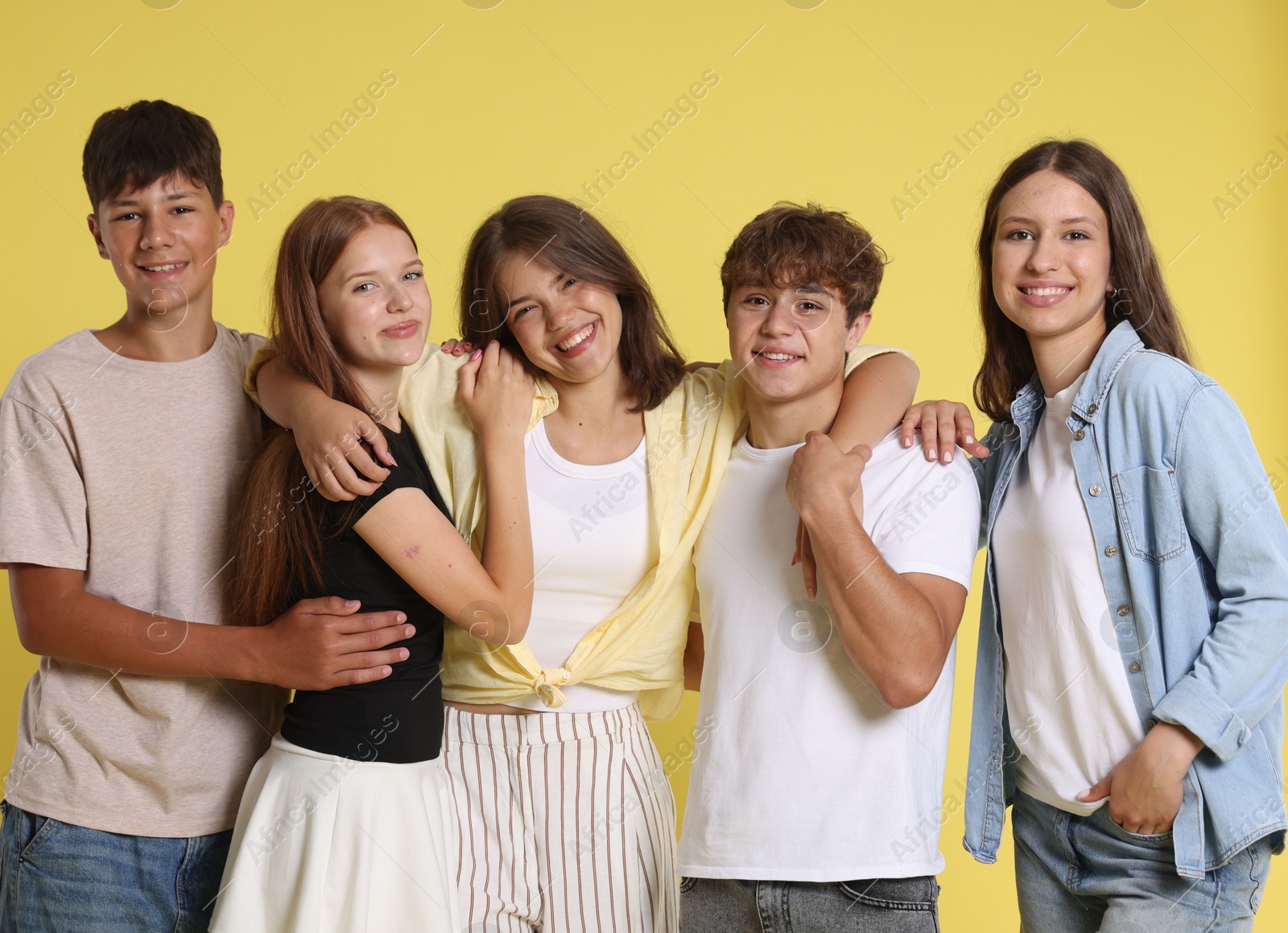 Photo of Portrait of happy teenage friends on yellow background