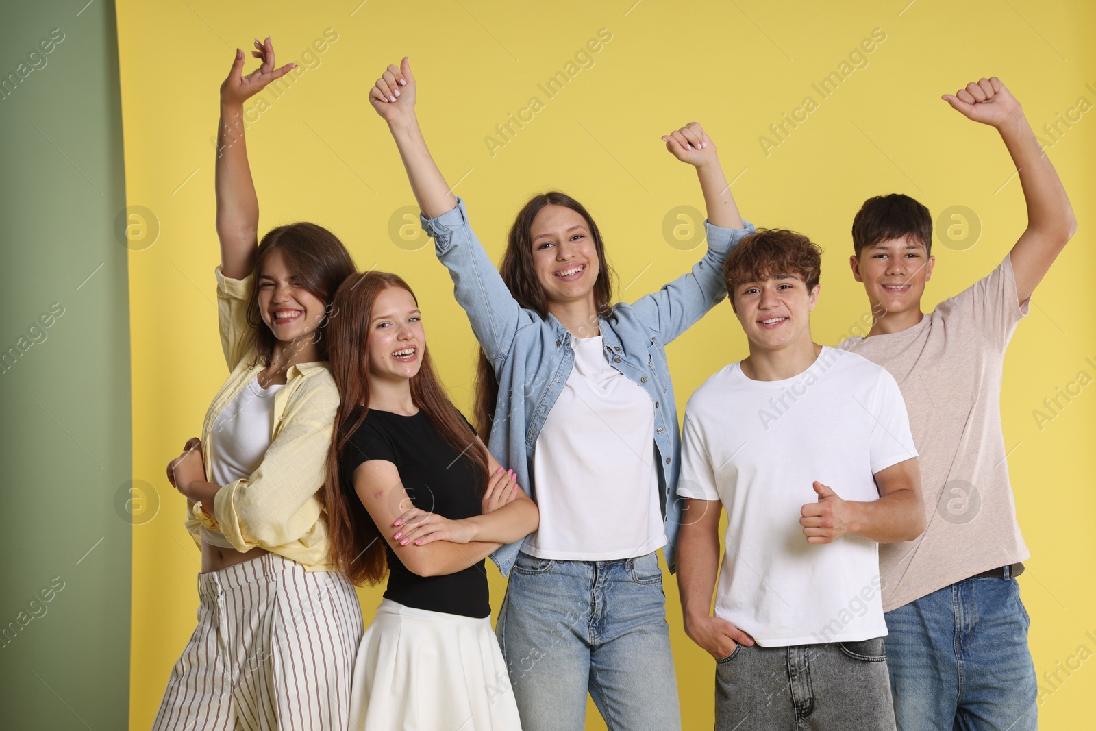 Photo of Portrait of happy teenage friends on yellow background