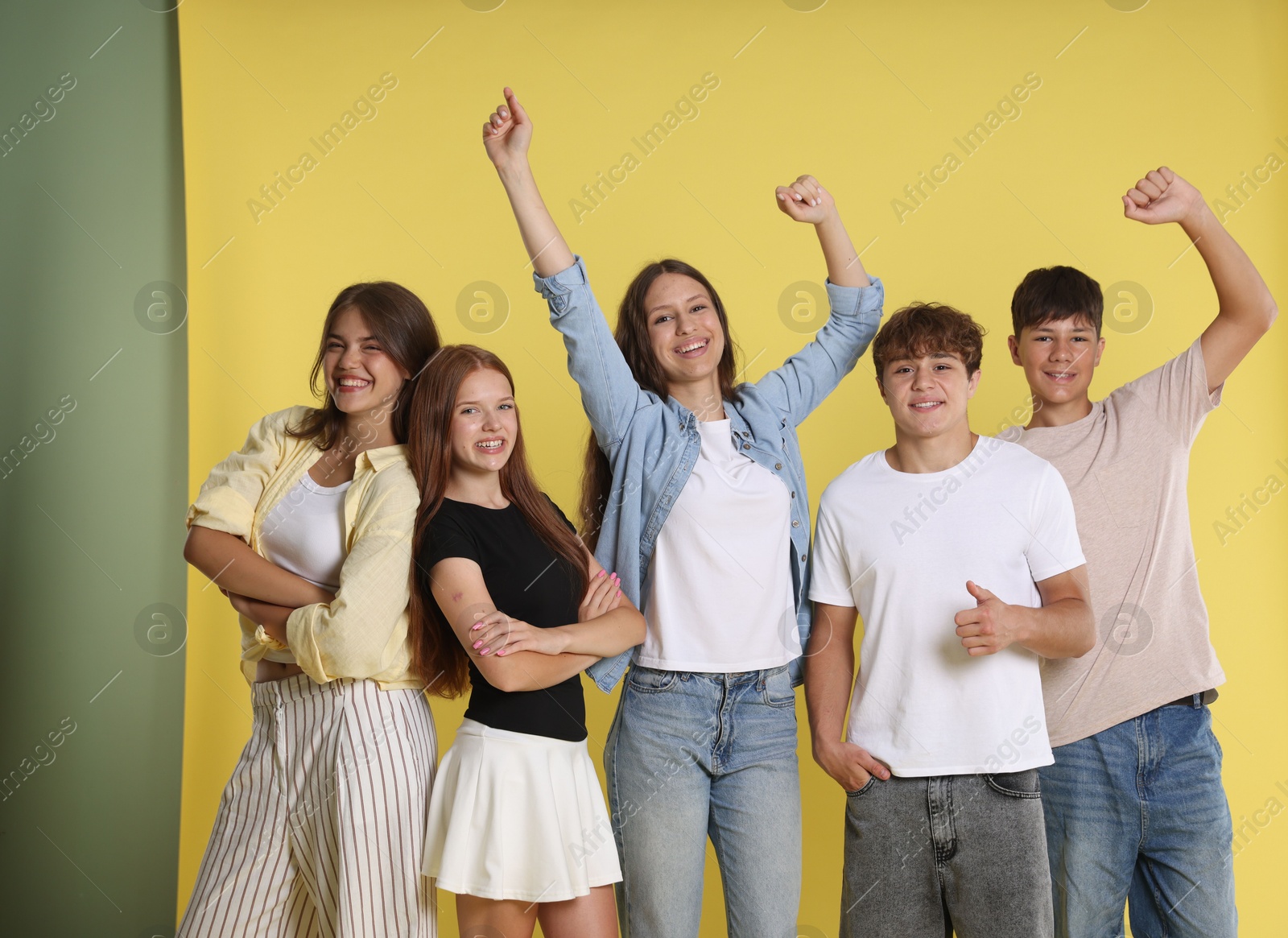 Photo of Portrait of happy teenage friends on yellow background