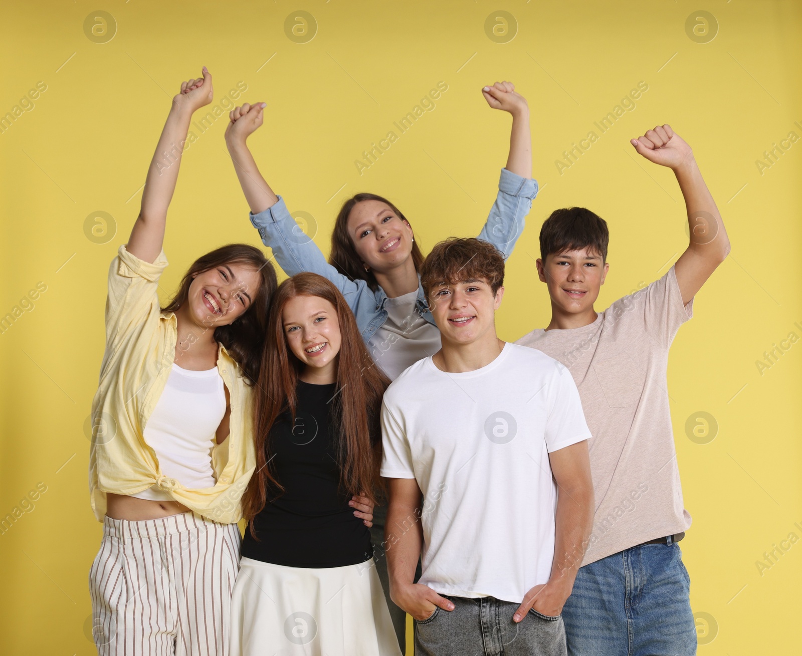 Photo of Portrait of happy teenage friends on yellow background
