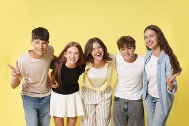 Photo of Portrait of happy teenage friends on yellow background