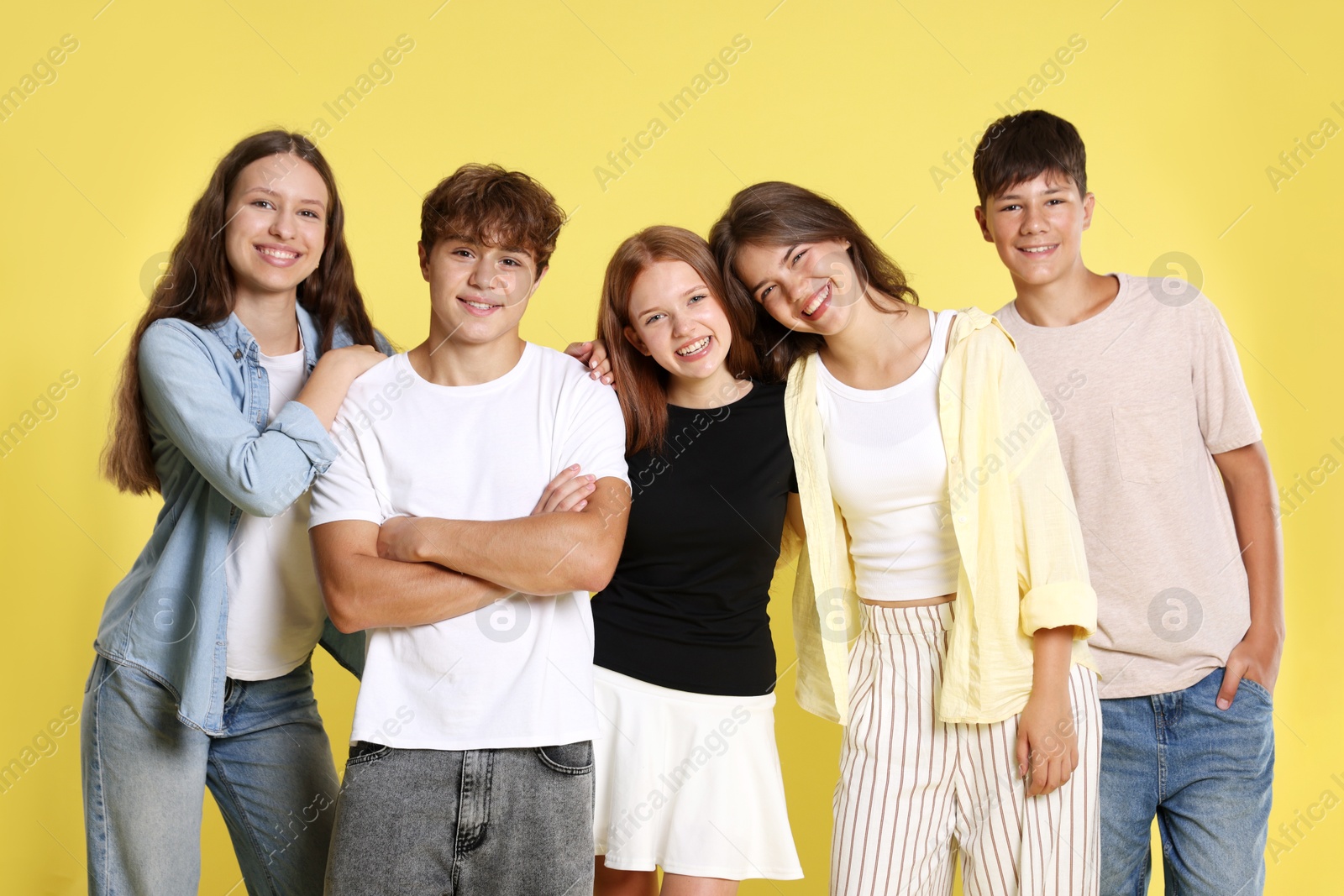 Photo of Portrait of happy teenage friends on yellow background