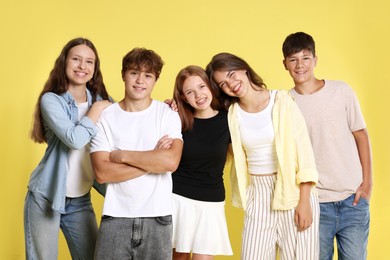 Photo of Portrait of happy teenage friends on yellow background
