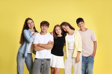 Photo of Portrait of happy teenage friends on yellow background