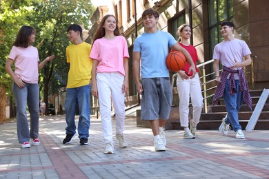 Photo of Group of happy teenage friends spending time together outdoors