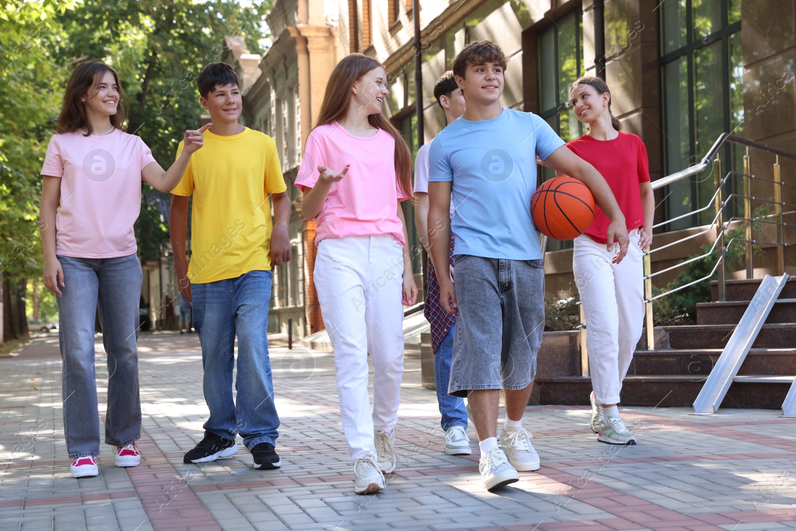 Photo of Group of happy teenage friends spending time together outdoors